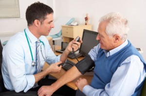 British doctor taking senior man's blood pressure