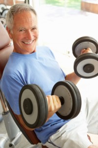 Senior Man Working With Weights In Gym