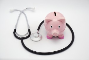 Pink piggy bank and stethoscope